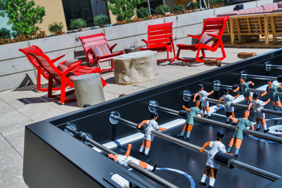GATHER courtyard with outdoor seating grilling stations and foosball
